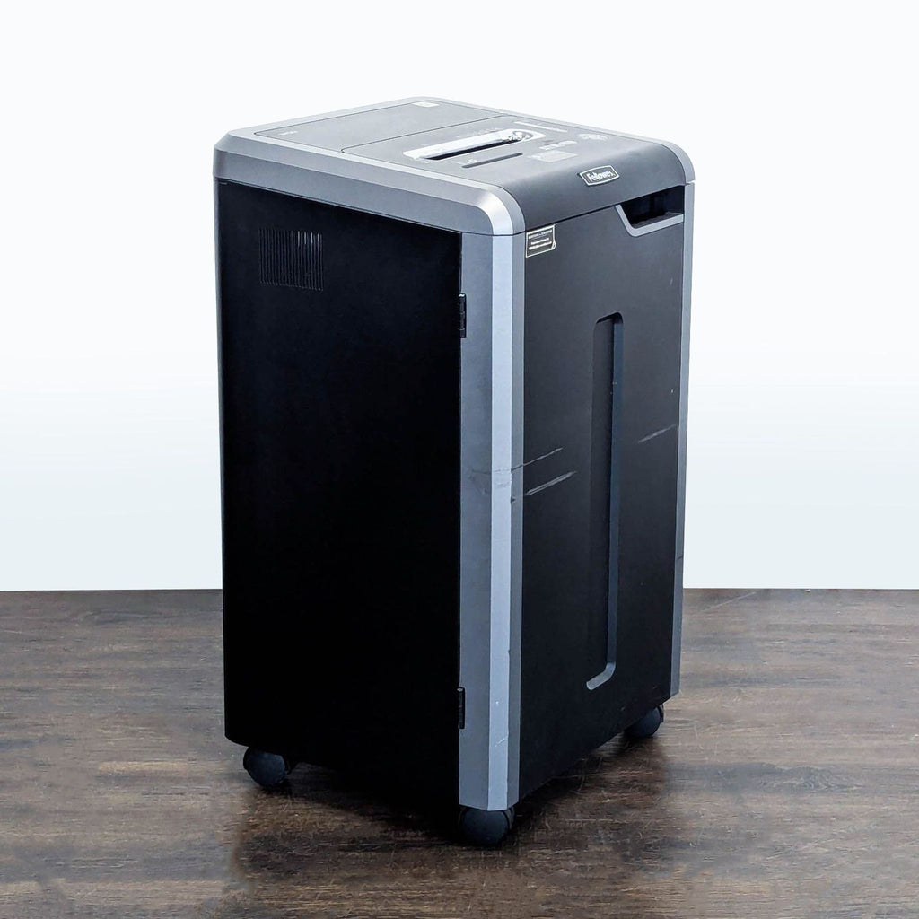 1. Fellowes black and silver paper shredder on wheels, shown angled on a wooden floor.