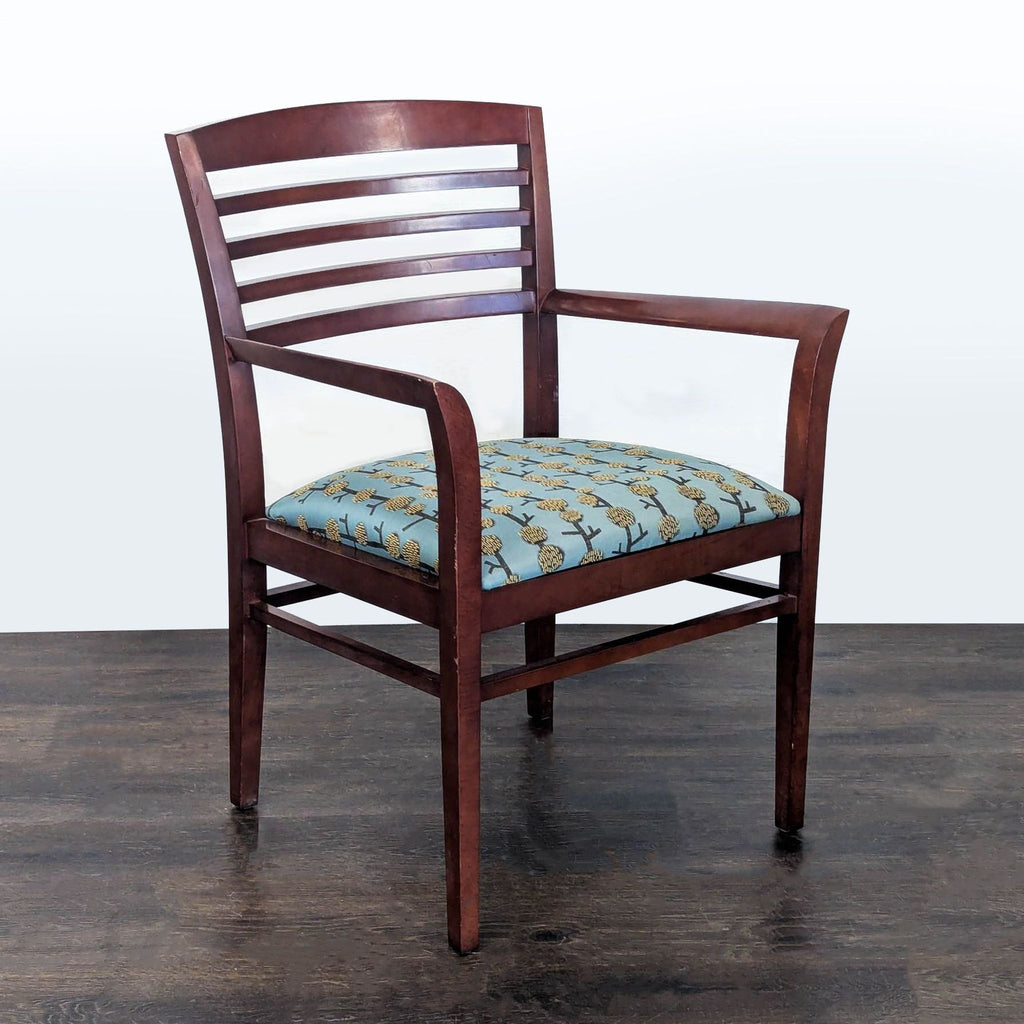 2. Angled view of a National wooden chair featuring curved arms and a blue cushion with a yellow floral design.