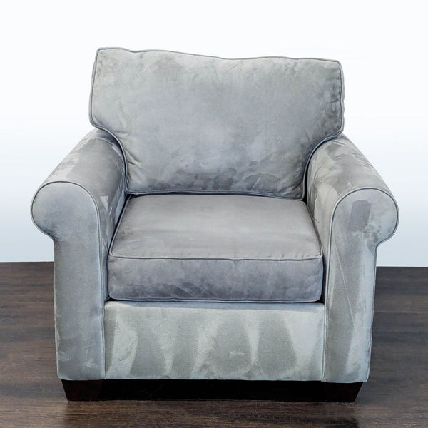 1. Front view of a gray Pottery Barn lounge chair with plush cushions and rolled arms on wooden flooring.  