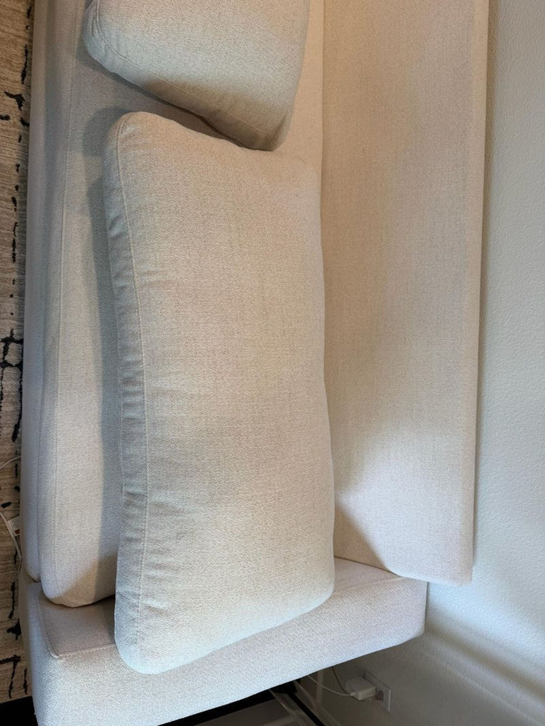 2. Comfortable Living Spaces branded three-seater sofa with plush cushions and sleek lines.  