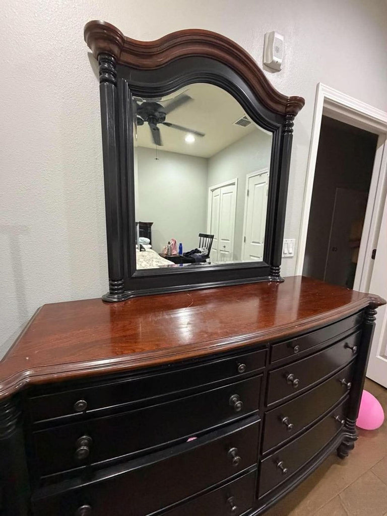 2. Black wooden dresser with ornate mirror, brown top surface, and multiple storage drawers, category: Dressers.