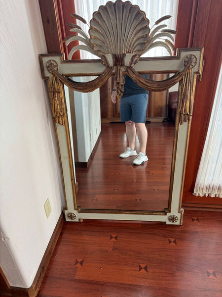 1. Ornate mirror with gold accents and a shell motif at the top, displayed in a room with wooden floors.  