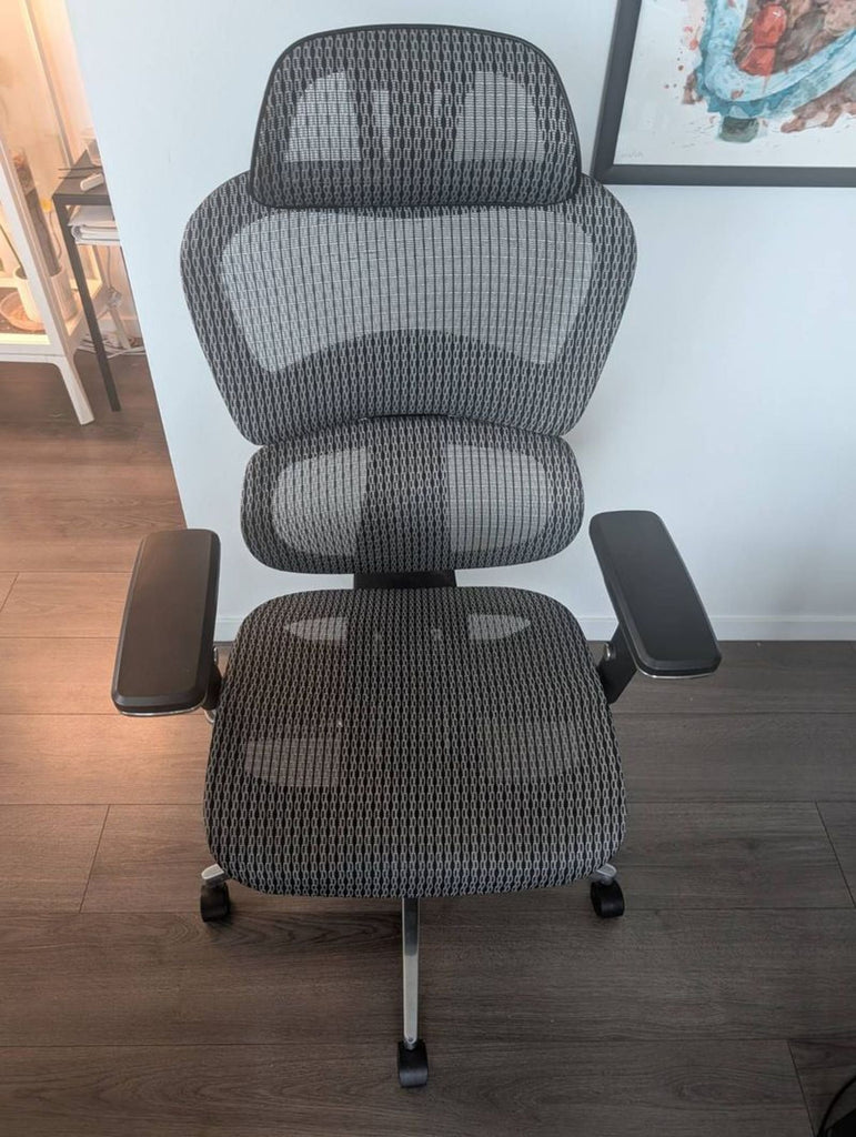 Ergonomic Reperch chair with mesh material, adjustable armrests, and lumbar support on a rolling base.