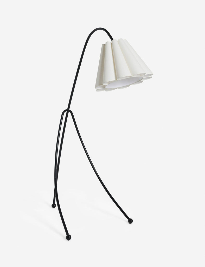A sculptural floor lamp with a black metal frame and white folded shade by Sarah Sherman Samuel.