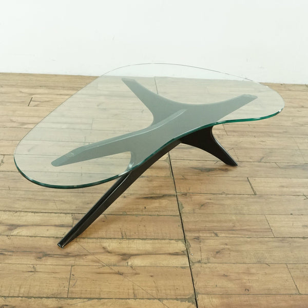 1. Kidney-shaped glass top coffee table with sculptural wood base from Scandinavian Designs, viewed at an angle.