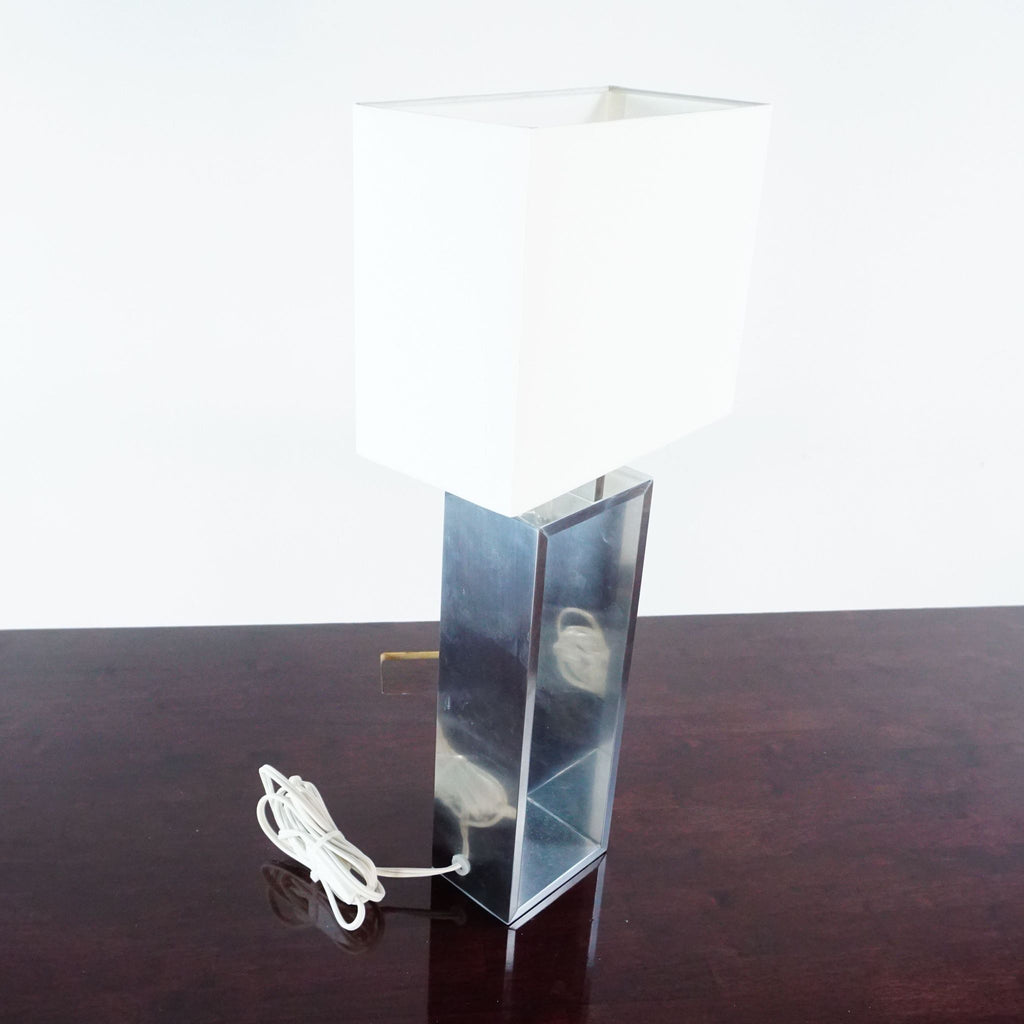 2. Modern Ikea lighting with a shiny aluminum base and white rectangular lampshade, power cord visible.