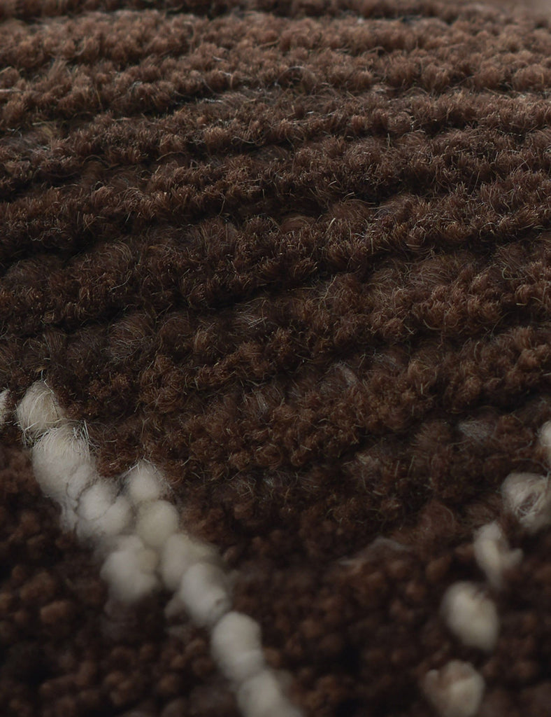 a close up of a brown and white rug.