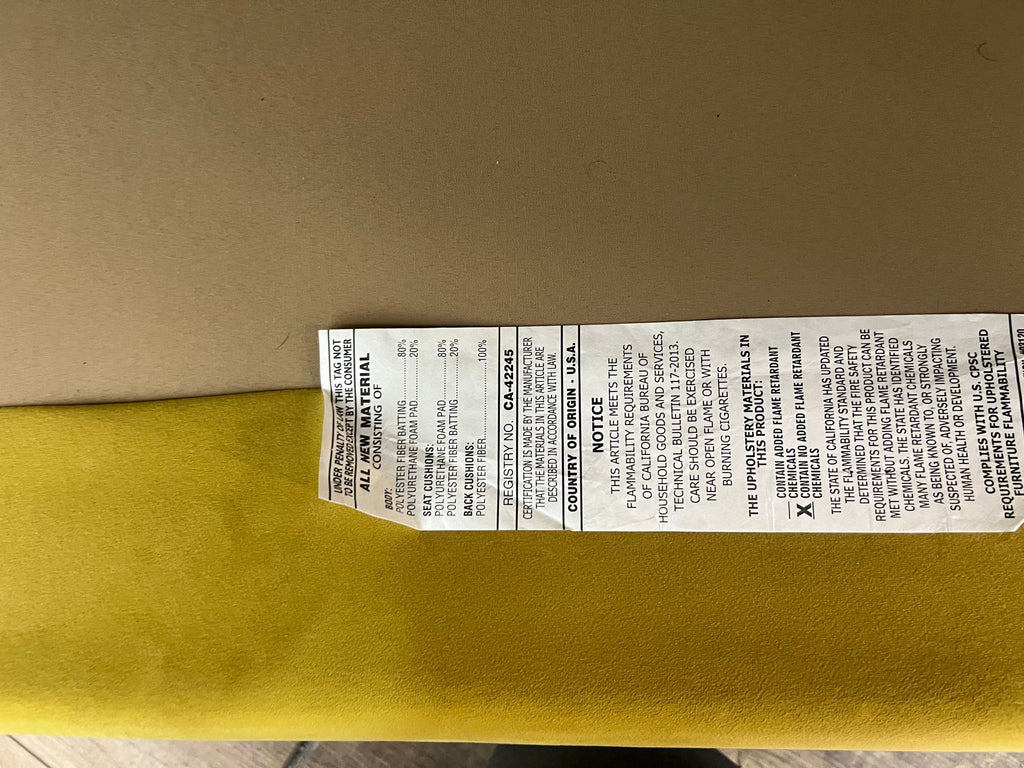 Close-up of material tag on Reperch velvet daybed with fabric information.