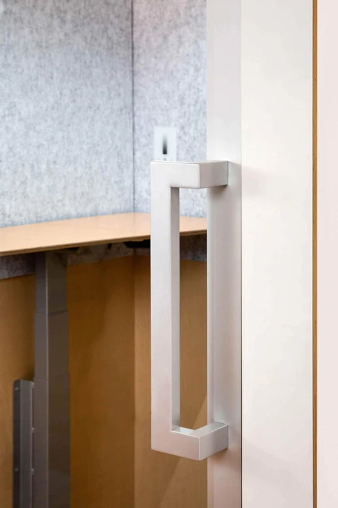 a white door handle with a white wooden desk.