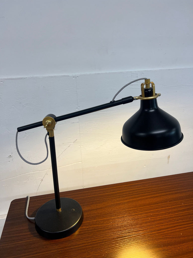 a vintage industrial desk lamp with a brass shade.