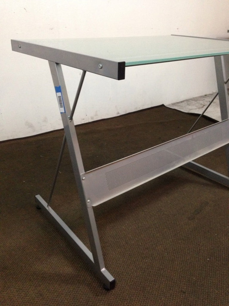 3. Close side angle of a Reperch desk showing slanted metal legs and frosted glass top, categorized as a desk.