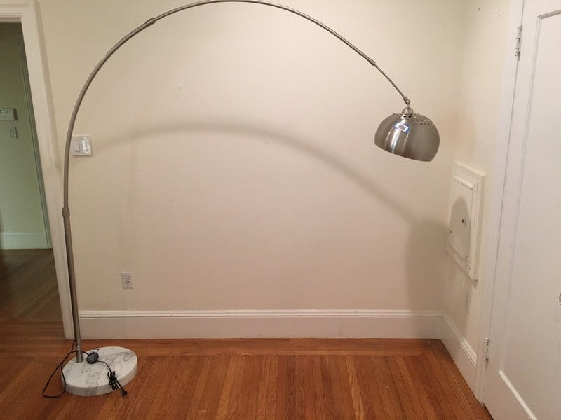 1. Reperch chrome and marble floor lamp with arc design, shown placed indoors on a hardwood floor.