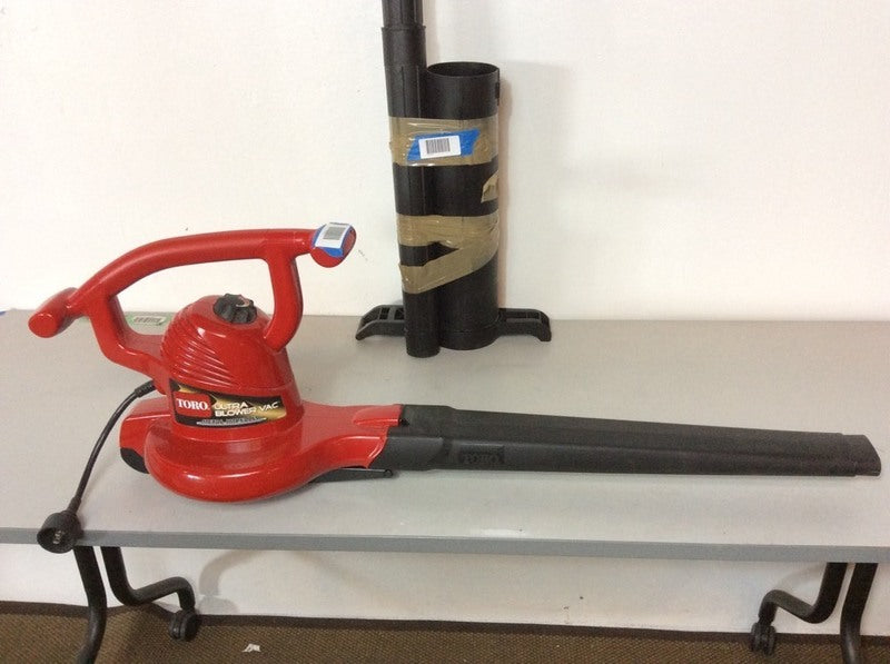 2. Toro Ultra Blower Vac by Toro, placed on a table, with accessory tube standing upright behind it.
