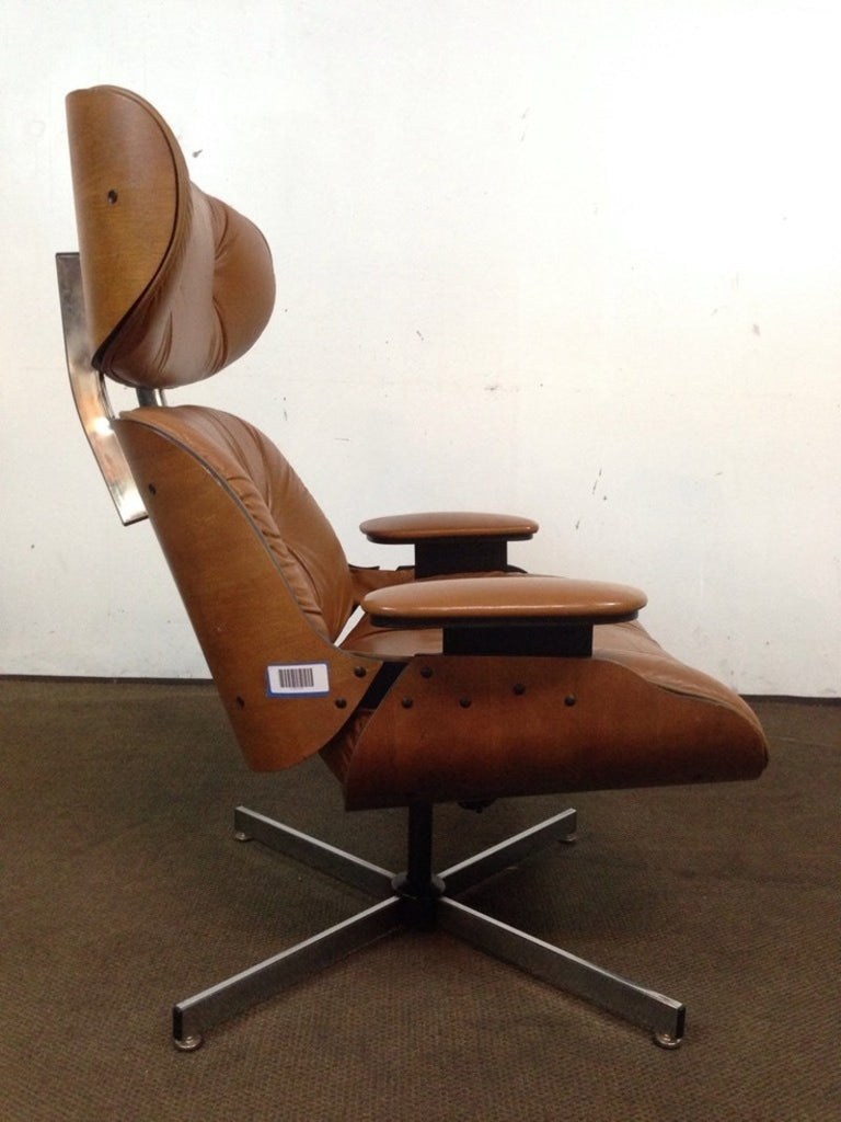 Side view of a Reperch chair in caramel leather and walnut veneer, featuring armrests and a four-footed metal base.