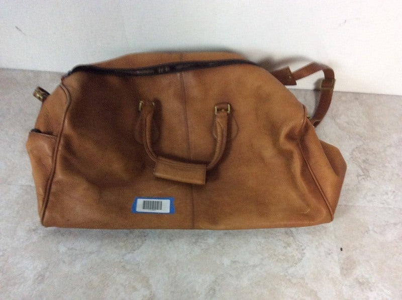 2. Brown Reperch travel bag with two handles and a barcode label, placed on a light floor.