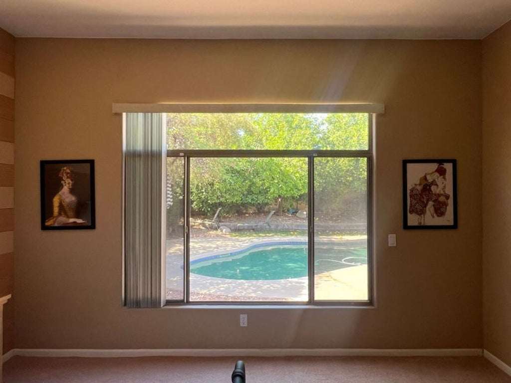 2. "Interior room with two Reperch framed prints on adjacent walls, overlooking a pool area with sunlight streaming through large window."