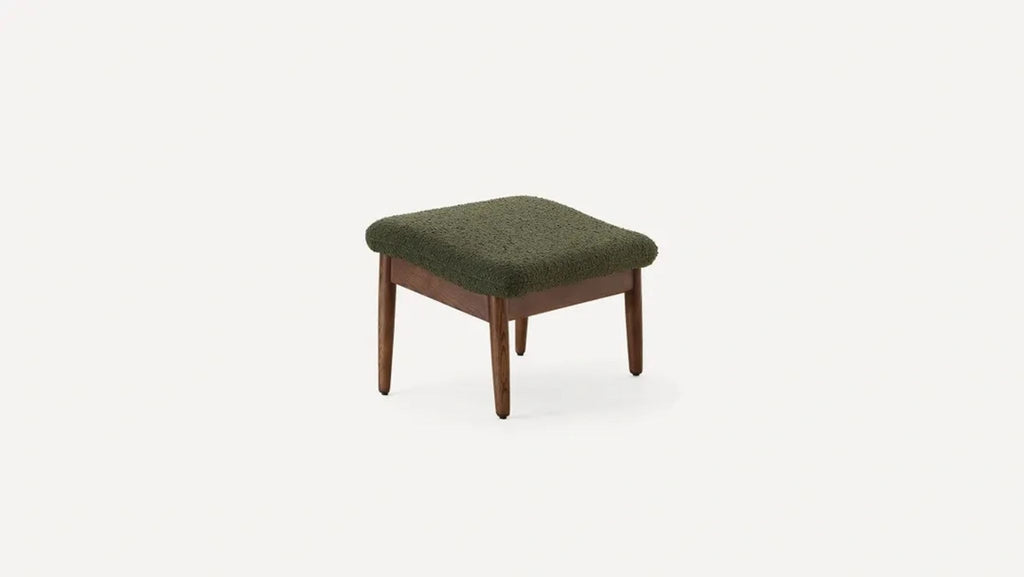 a stool with a green fabric upholstery.