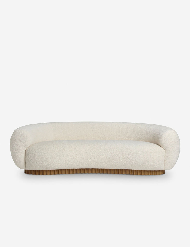 1. Front view of a Reperch 3-seat sofa with curved, cream upholstery and a ribbed wooden base.  
