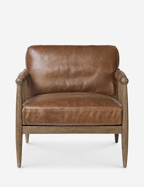 1. Front view of a Lulu and Georgia brown leather lounge chair with wooden frame and padded armrests.  