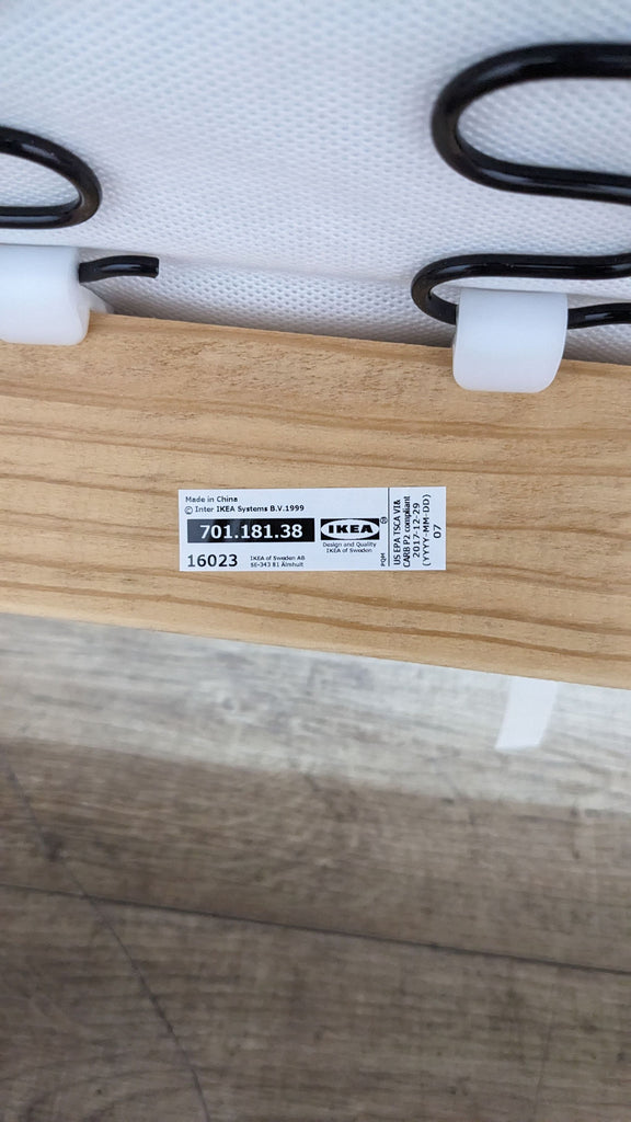 Close-up of Ikea label on the wooden frame of a sofa.