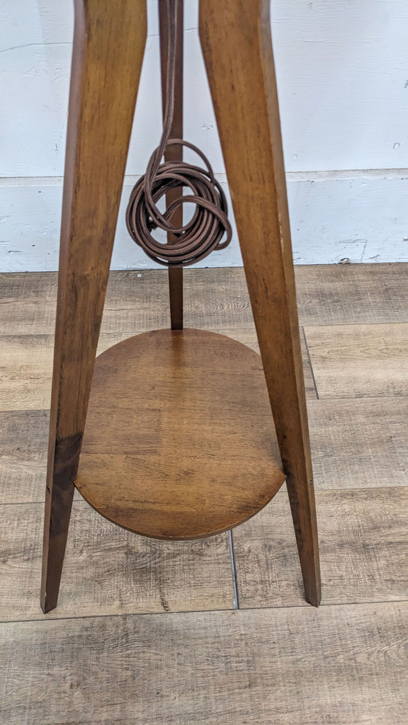 Detail of the Reperch floor lamp's base showing the lower shelf.