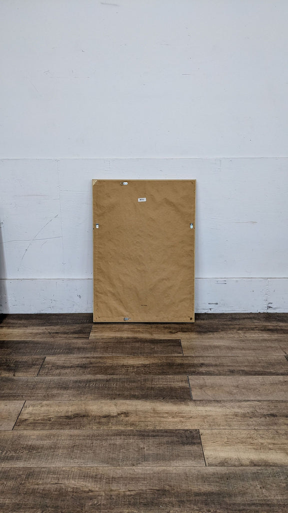 Back of Reperch mirror with paper cover against white wall.