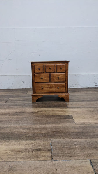 Front view of an Ethan Allen wooden end table with six drawers.