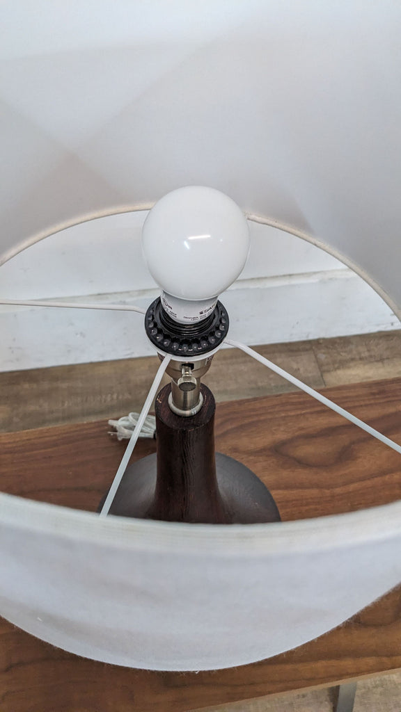 Close-up of the light bulb inside the Reperch lamp with a white shade.