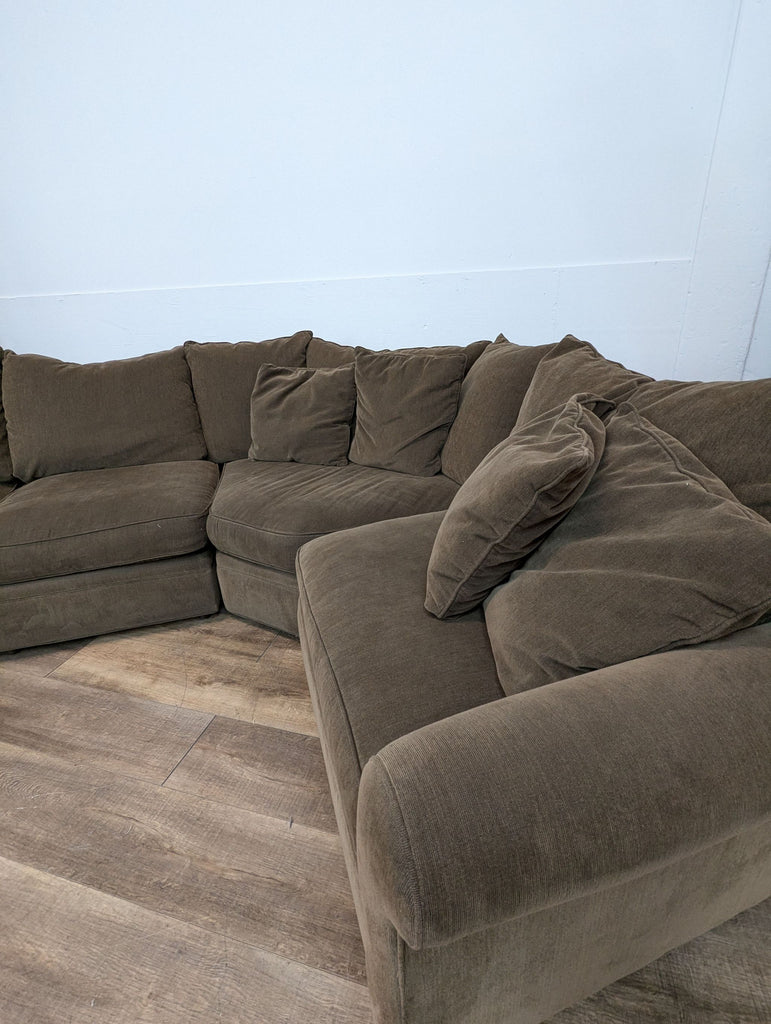 Close-up view of brown BluDot sectional corner seating.
