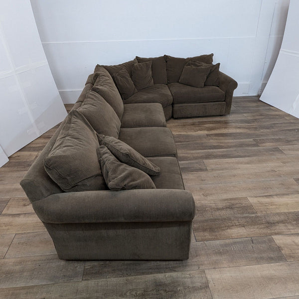 a brown couch sitting on top of a wooden floor.