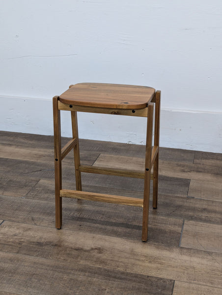 a mid century modern stool with a shelf.