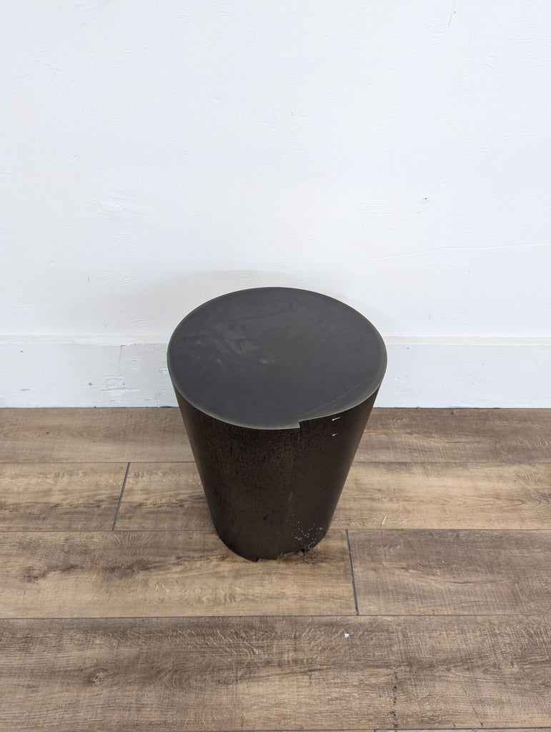 a black metal stool with a black metal top.