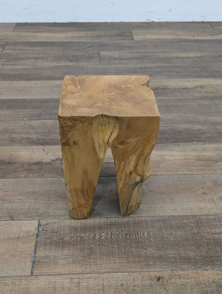 a wooden stool with a split trunk.