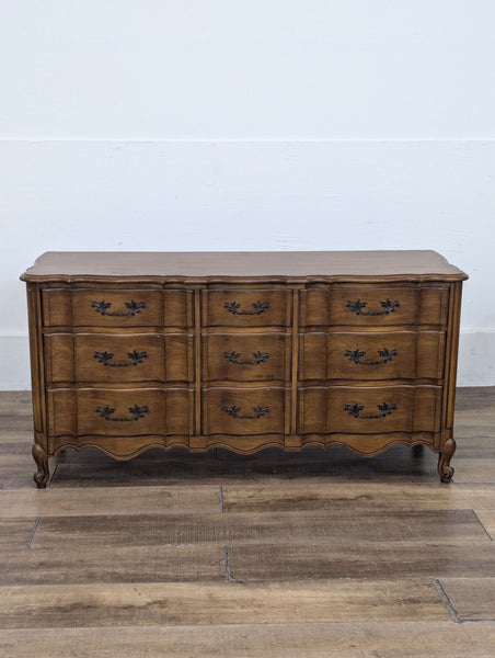 1. Vintage wooden dresser with ornate handles by White Fine Furniture, featuring nine drawers and curved detailing.