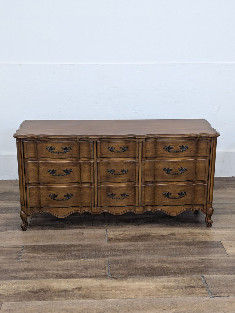 3. Front view of a French provincial-style dresser from White Fine Furniture with decorative metal hardware.