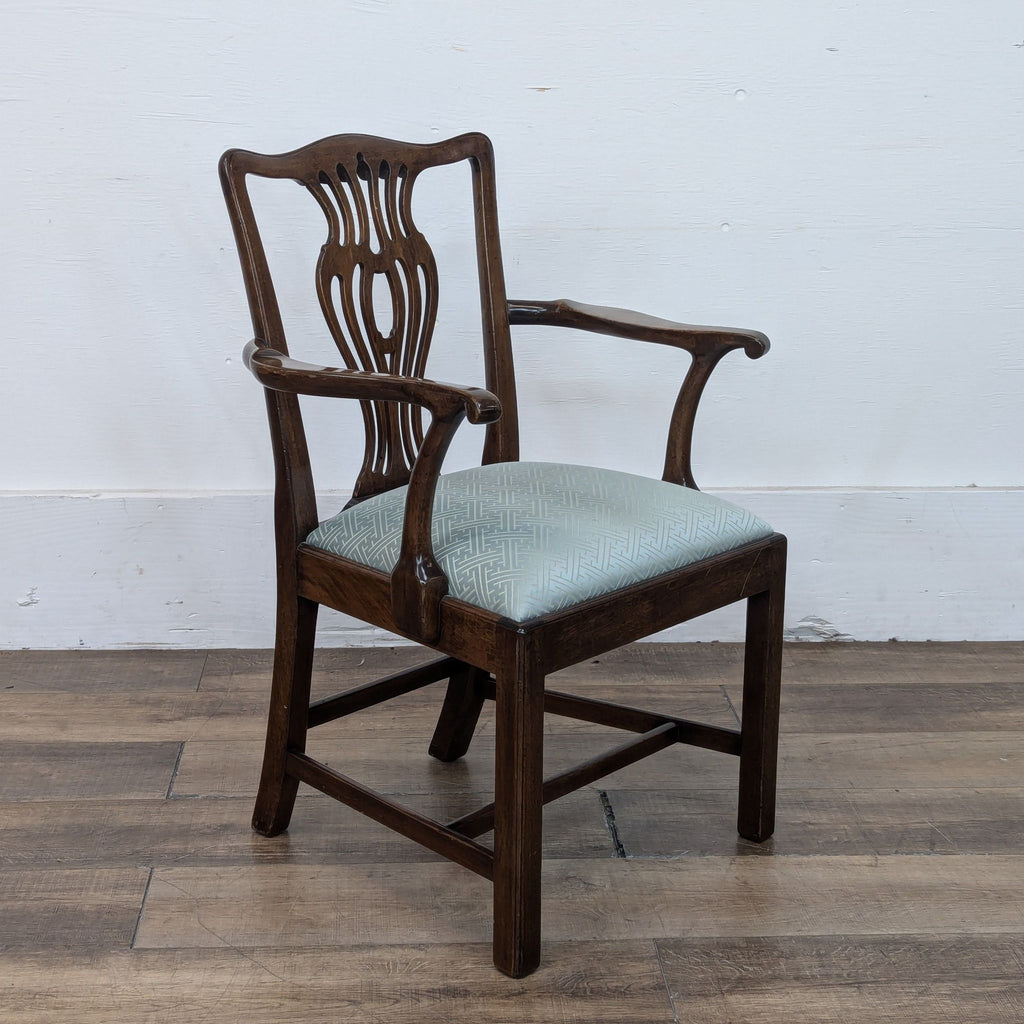 Single mahogany dining chair with armrests and intricate back design in George III style.  
