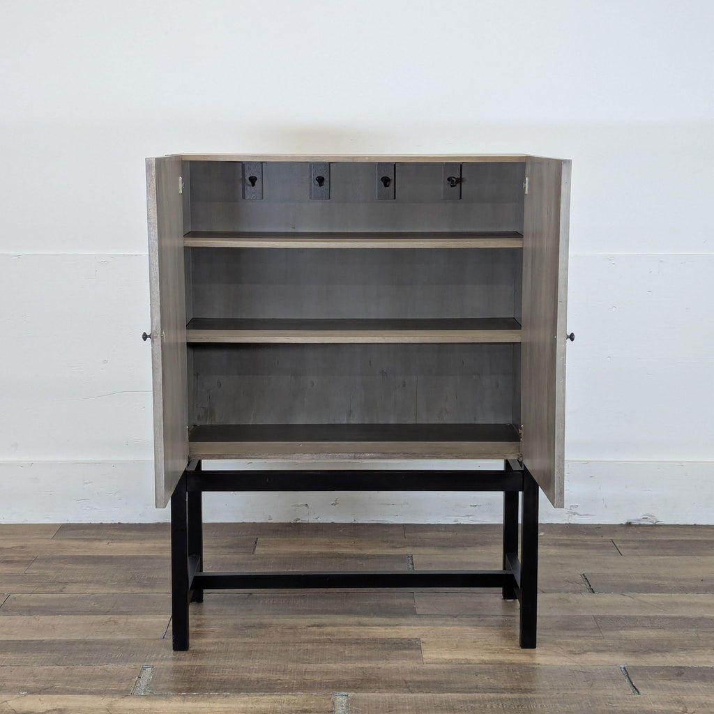 2. Reperch cabinet open, showing interior shelving and hooks for storage, on a sturdy metal frame.