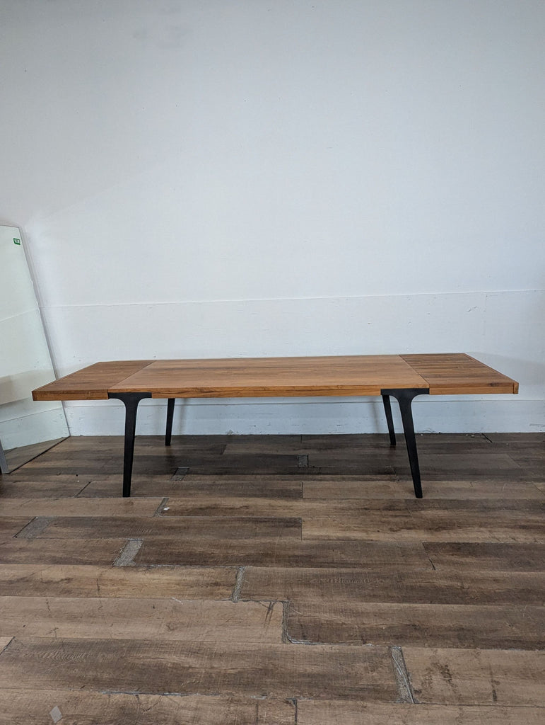 2. Crate & Barrel dining table, rectangular wood surface with black legs, viewed from the front in an empty room.  