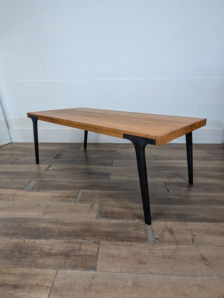 1. Rectangular Crate & Barrel dining table with a natural wood top and black metal legs on wood flooring.