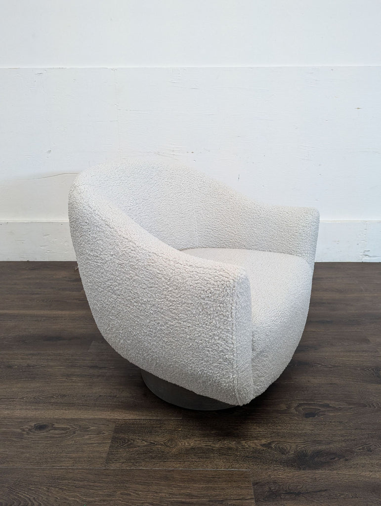 3. Angled view of a plush white Interlude Home lounge chair with a round metal base and cozy contemporary style.