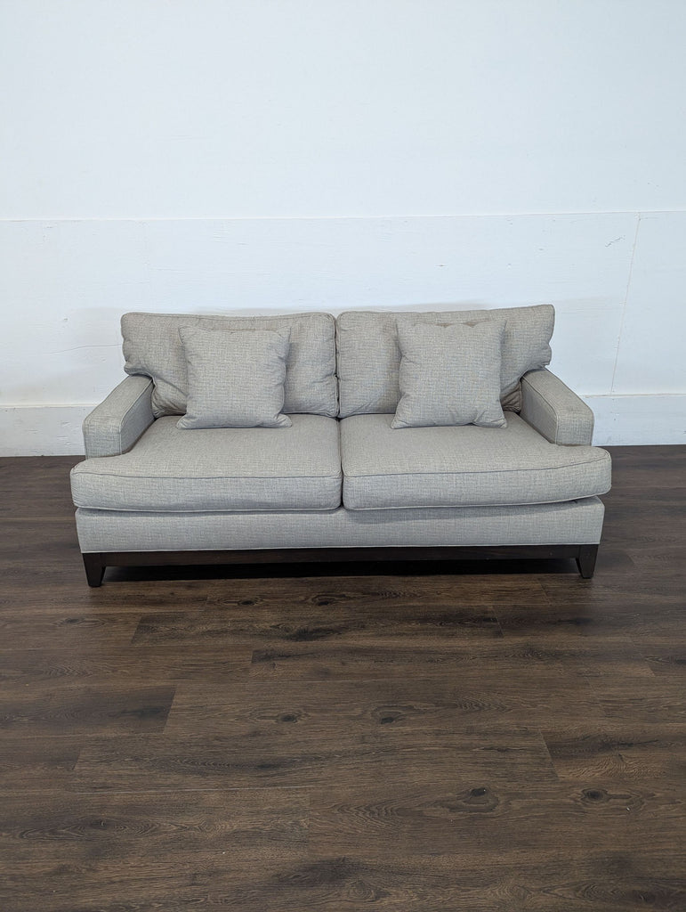 2. Front view of an Ethan Allen 3-seat beige sofa on dark wood flooring, featuring loose back and seat cushions.