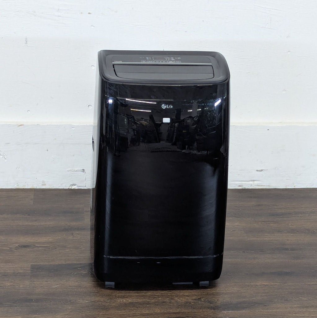 2. Front view of a black Reperch portable air conditioner, category AC & Fans, on a wooden floor.