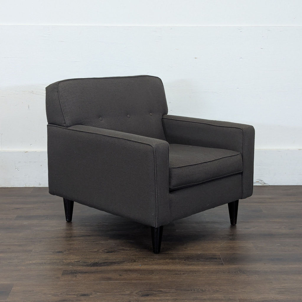 2. Angled view of a Reperch lounge chair in dark gray, showing cushioned seat and modern arms.  