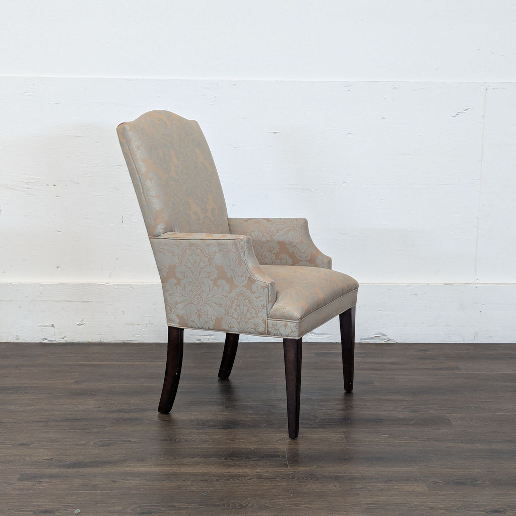 2. Side view of Reperch patterned armchair with padded seat, arms, and dark wooden legs on wood floor.
