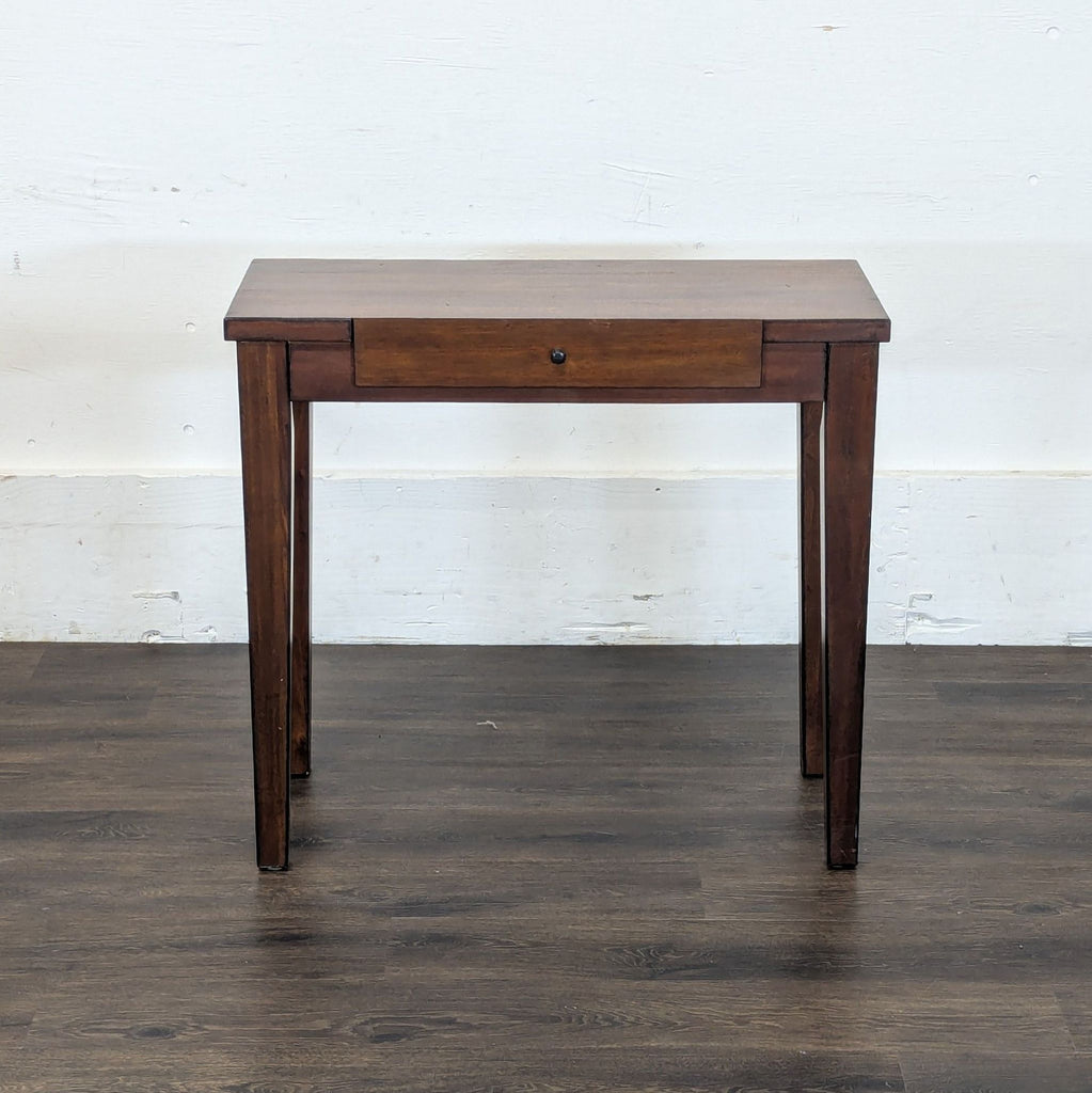 1. Reperch side and console table in dark wood, features one center drawer, shown against a white wall.  