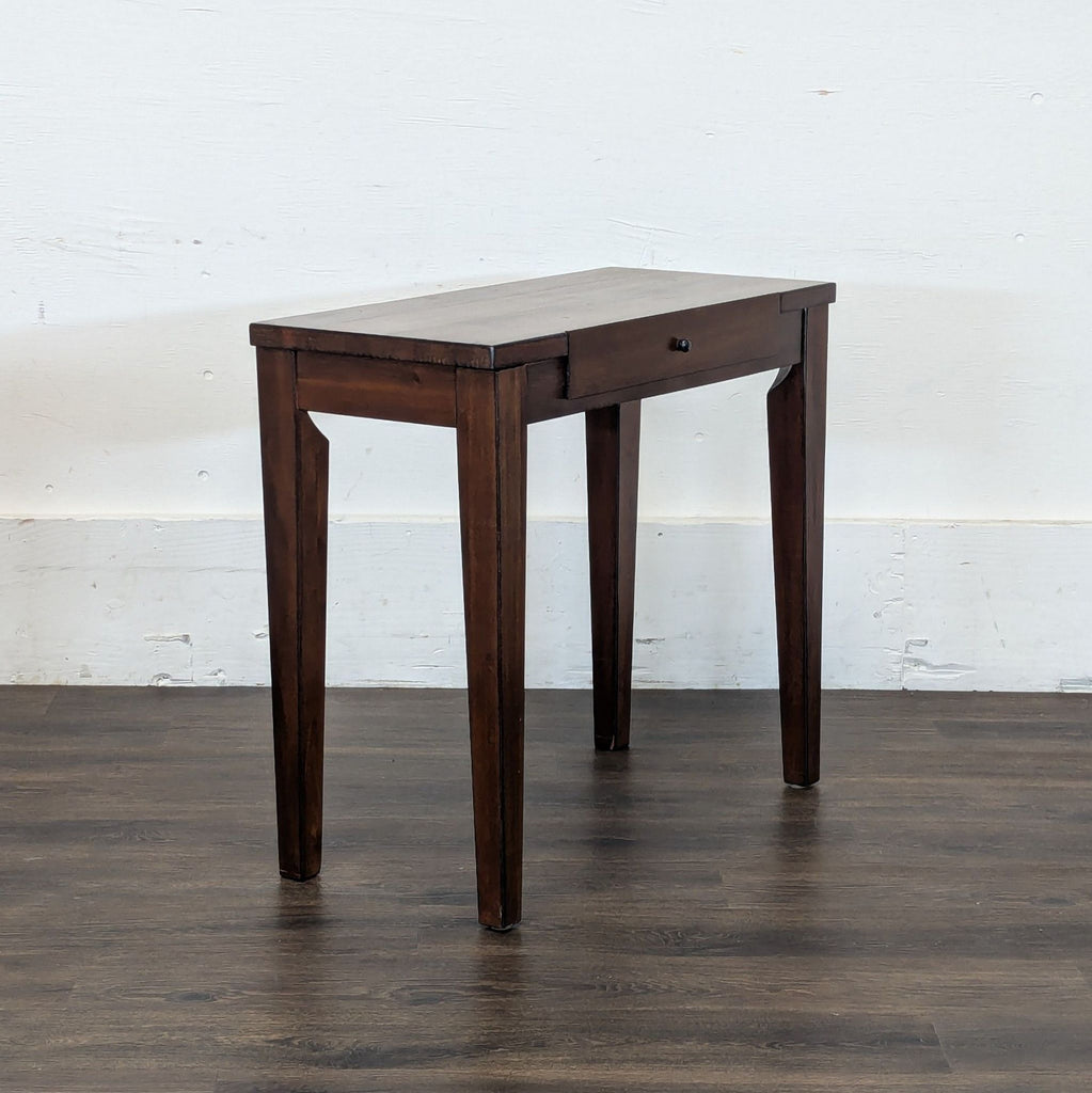 2. Angled view of Reperch dark wood side and console table, highlighting its tapered legs and single drawer.  