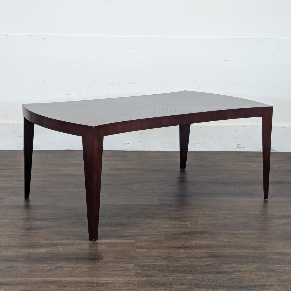 3. Angled side view of the New Studio Custom Naples Dining Table, highlighting its unique shape and rich wood tone.