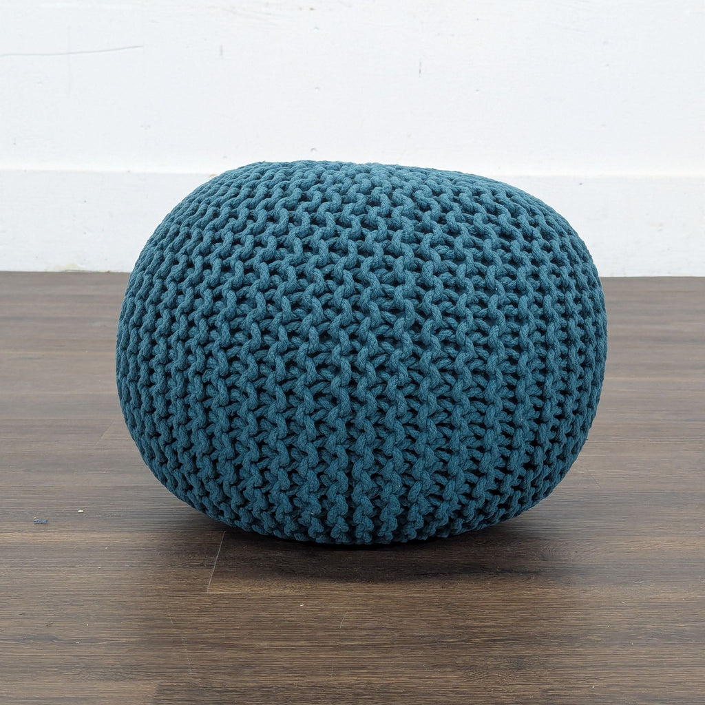 2. Close-up side view of a blue Reperch knit ottoman stool, highlighting its chunky woven texture.