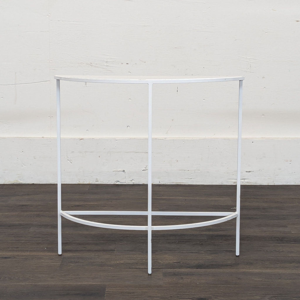 1. White metal half-moon console table by Reperch, with minimal frame, placed against a plain wall.