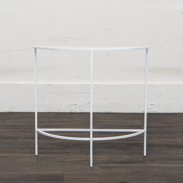1. White metal half-moon console table by Reperch, with minimal frame, placed against a plain wall.